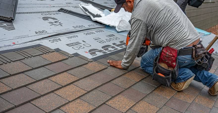 Roofing contractor installing shingles on a home in Oklahoma, OK